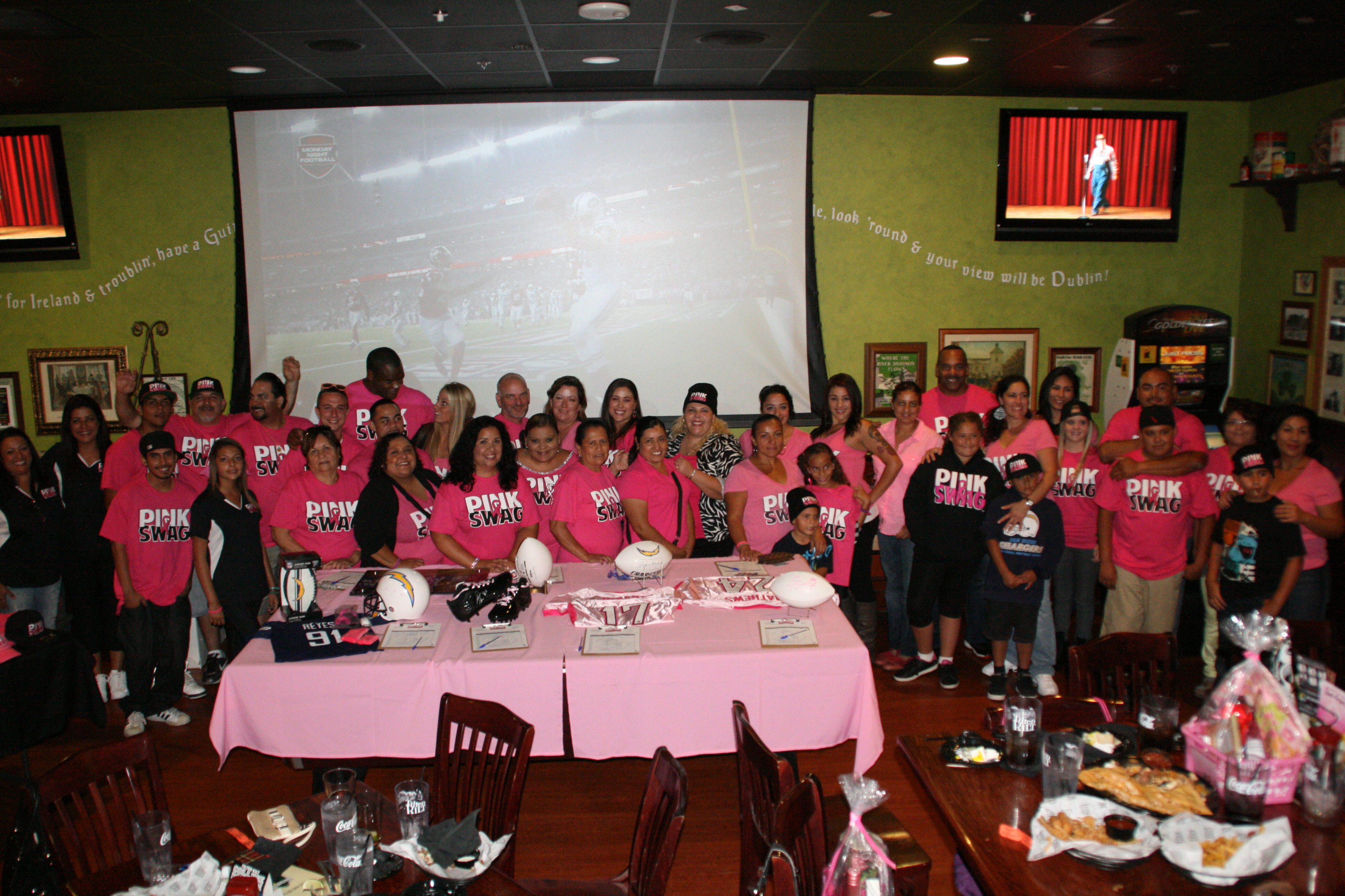 Large breast cancer support gathering with many people wearing pink
